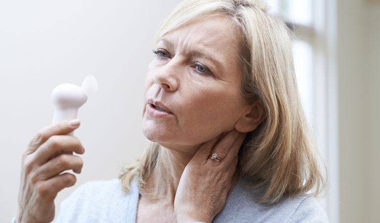 Older Woman Experiencing Hot Flush From Menopause